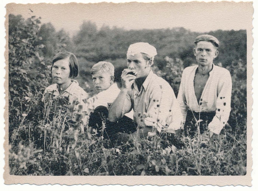 Alfonsas Nyka-Niliūnas (groja lūpine armonikėle) su seserimi Ona ir broliais Stasiu (kairėje) bei Adolfu (dešinėje). Apie 1938 metus Nemeikščiuose. Maironio lietuvių literatūros muziejaus archyvo nuotrauka