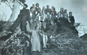 Seminaristai ir jų auklėtojas Adolfas Ramanauskas-Vanagas (centre, su akordeonu) iškylauja. Veronika Šarakauskaitė (Šimukonienė) paskutinėje eilėje pirma iš dešinės. Kitoje pusėje užrašas: „Nemuno pakrantėje, prie girininko. Alytus, 1943 m.“